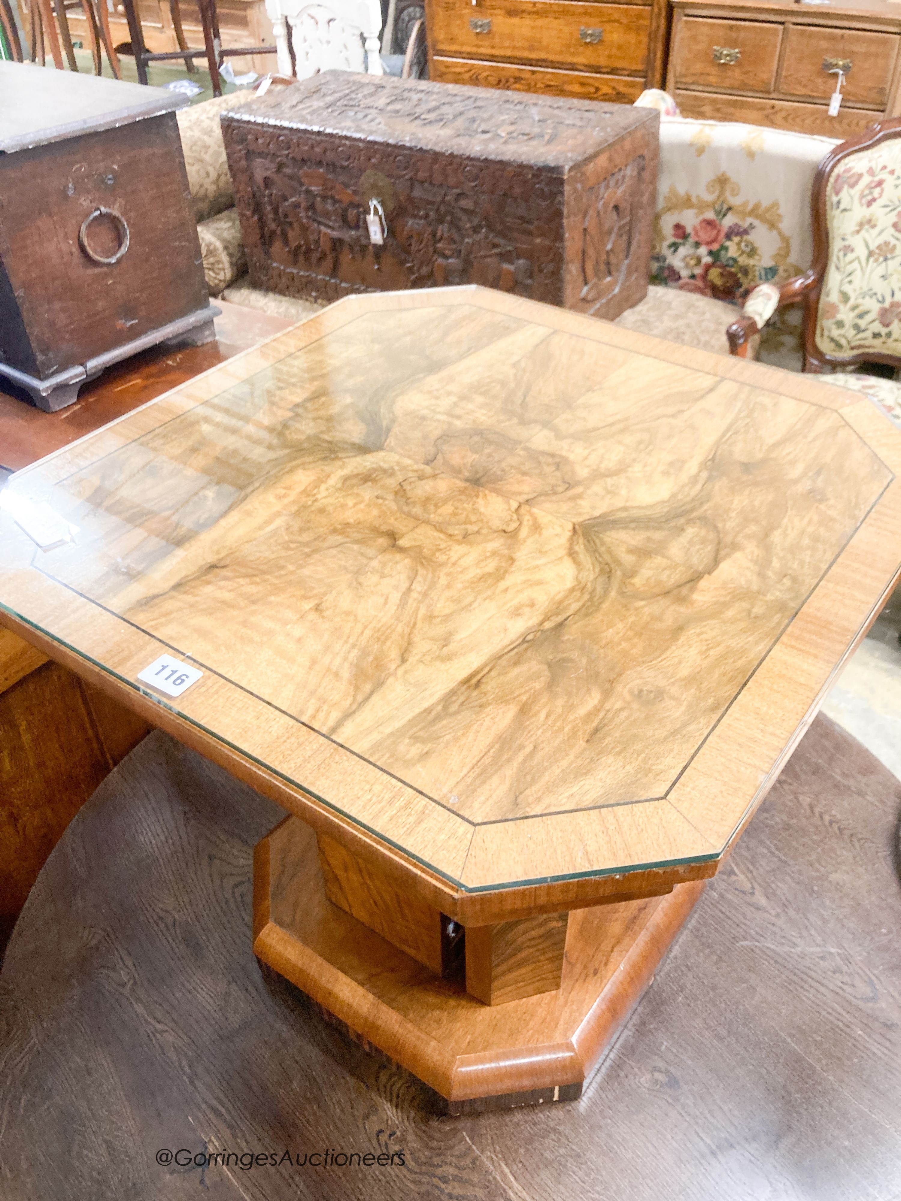 An Art Deco style octagonal figured walnut coffee table, with cupboard column, width 57cm, height 51cm